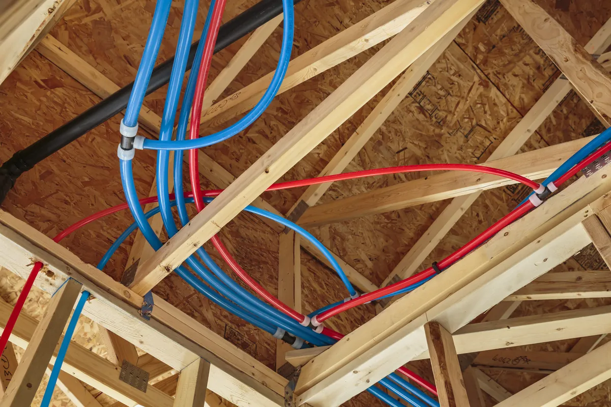 Red and blue PEX water lines run through attic trusses – Water Hammer and Banging Pipes in Dana Point Homes for Dana Point, CA homes