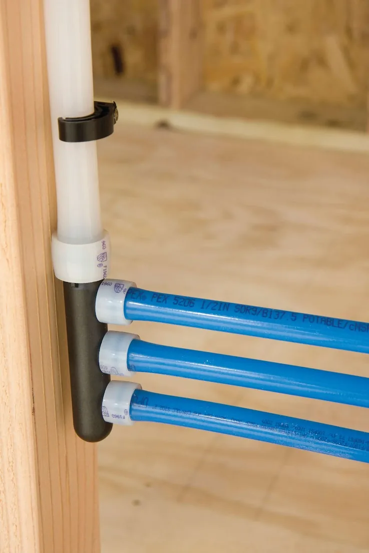 Blue PEX lines leaving a manifold fastened to a wall stud, from our Dana Point guide: Before Your Rinnai Tankless Water Heater Installation